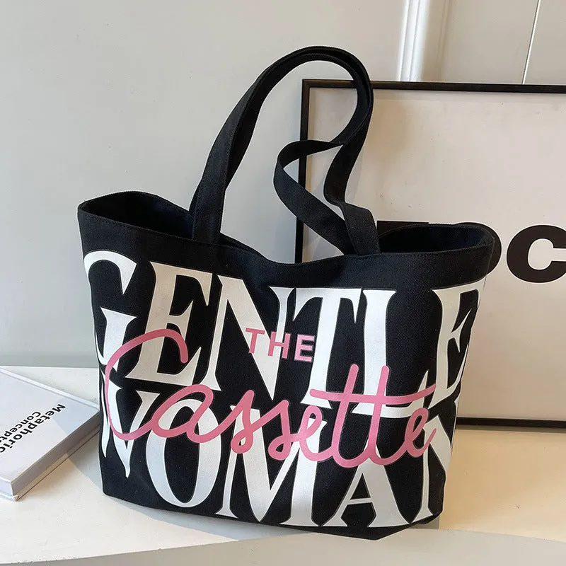 Canvas tote bag with letter print and car stitching detail in medium size 40x7x32cm available in black