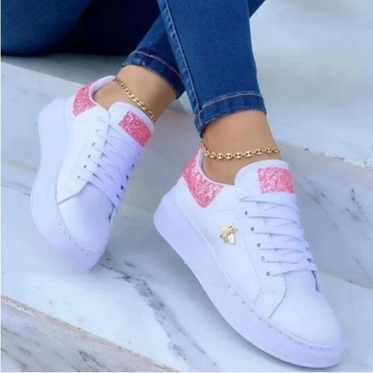 White low-top platform sneakers with lace-up closure and rubber sole on a light background