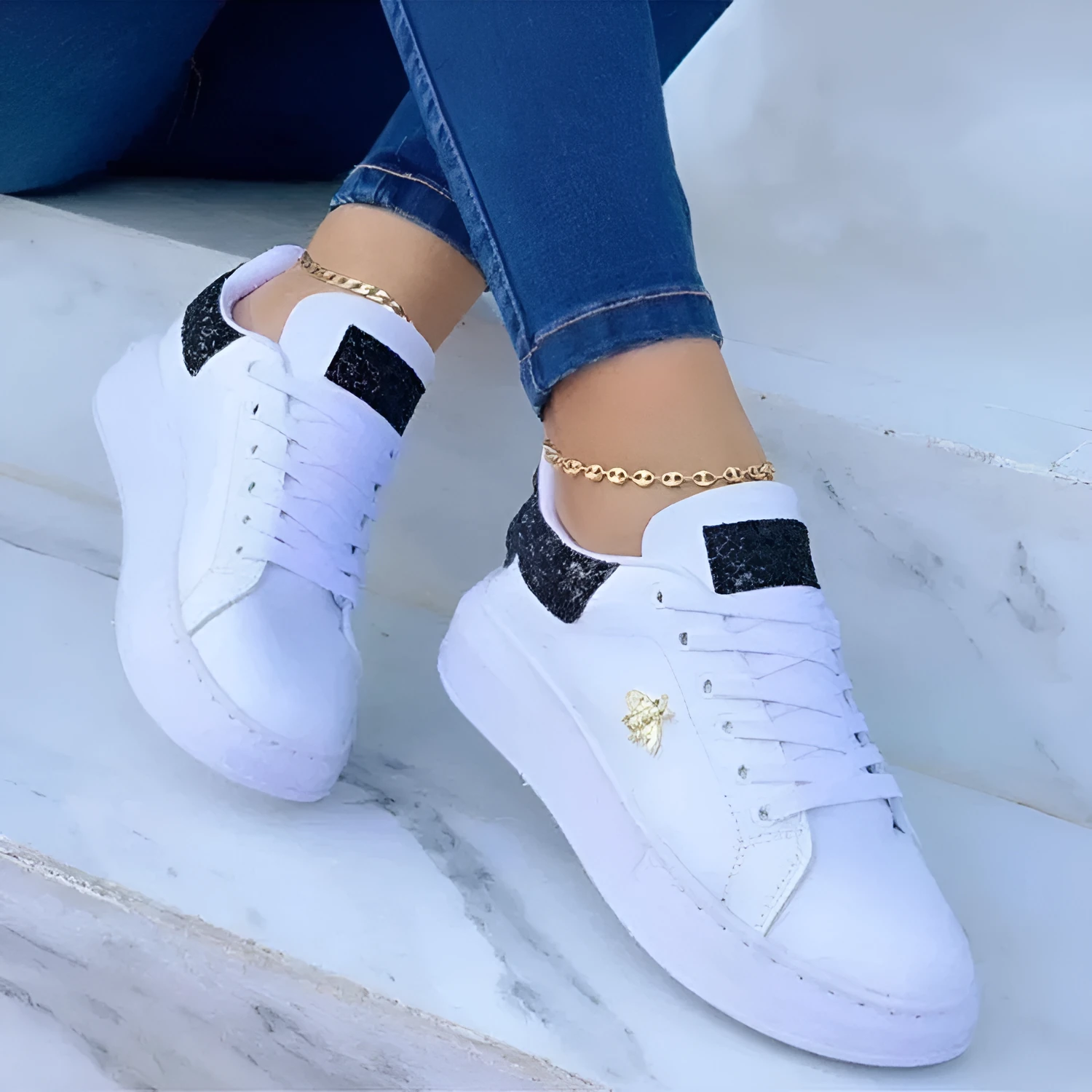 White low-top platform sneakers with lace-up closure and rubber sole on a light background