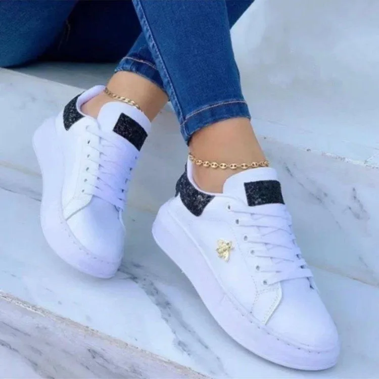 White low-top platform sneakers with lace-up closure and rubber sole on a light background