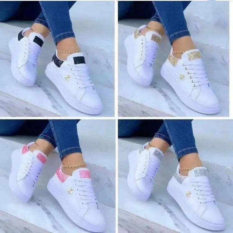 White low-top platform sneakers with lace-up closure and rubber sole on a light background