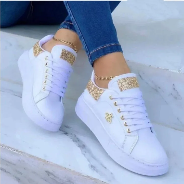 White low-top platform sneakers with lace-up closure and rubber sole on a light background