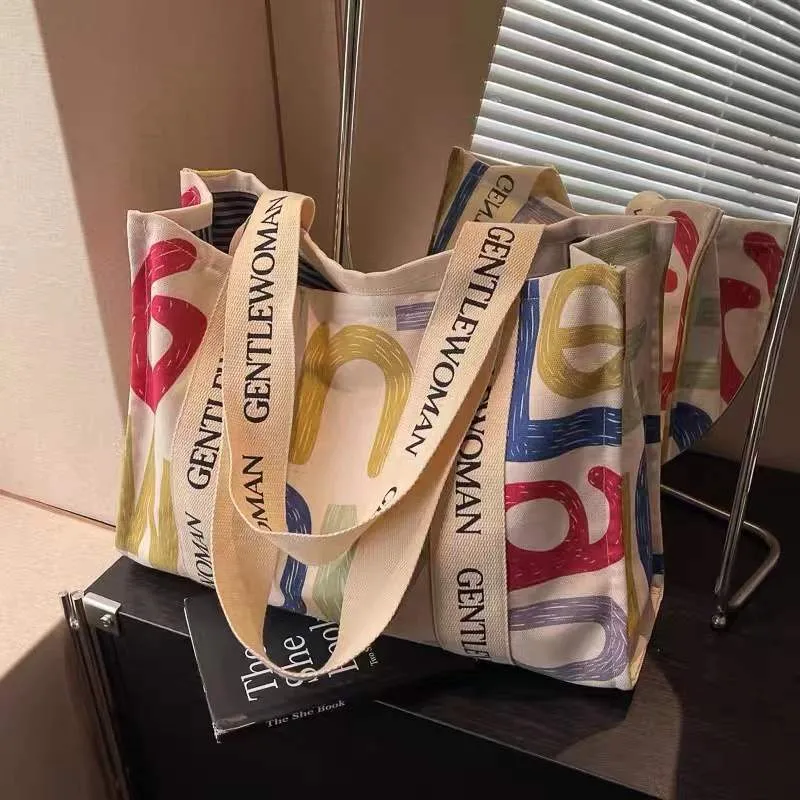 Large women's canvas tote bag with printed design, shown in available colour options.