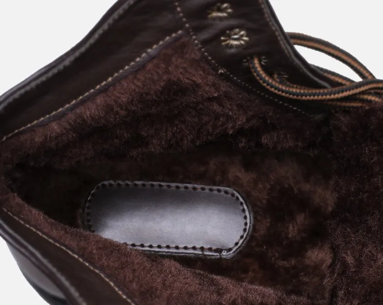 Men's brown embossed leather Martin boots with mid-top cut, round toe, thick heel, and front strap on a wooden floor
