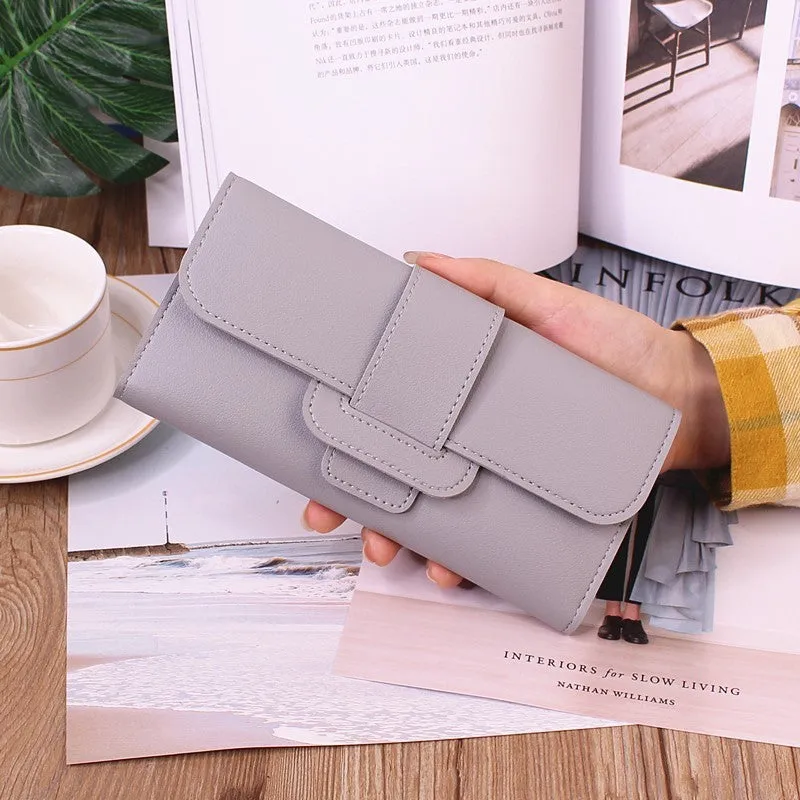 Women's long tri-fold wallet in light grey PU leather with sewing thread detail, open to show multiple card slots and cash compartments.