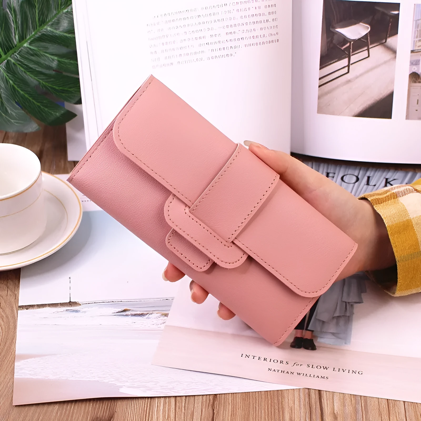Women's long tri-fold wallet in light grey PU leather with sewing thread detail, open to show multiple card slots and cash compartments.