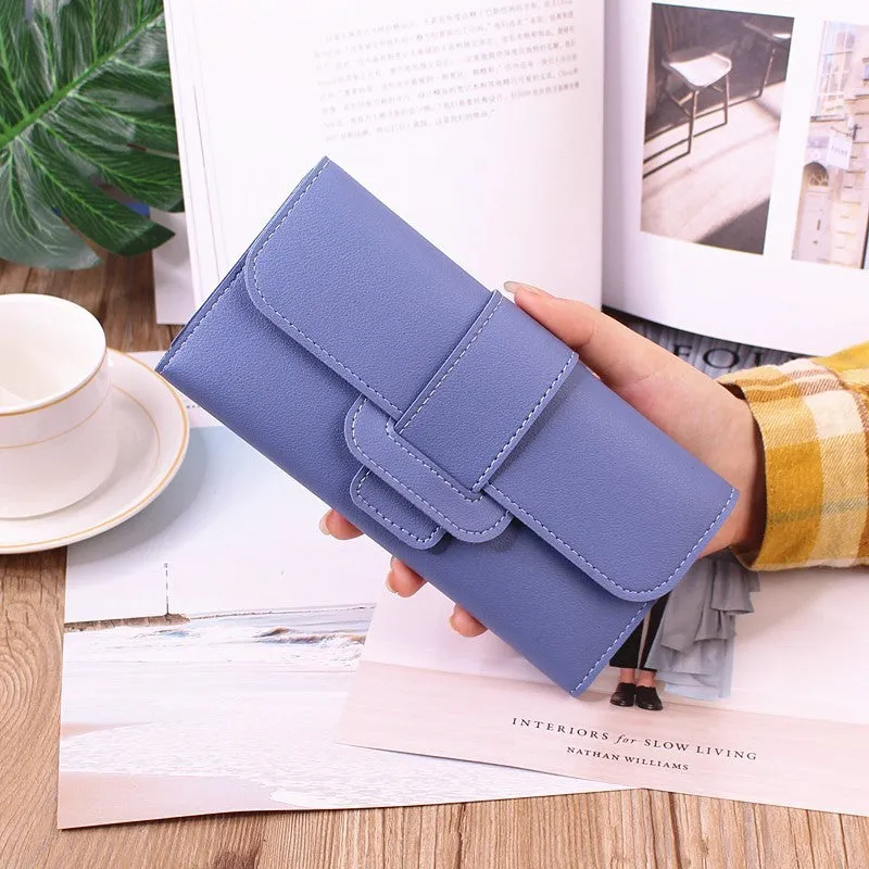 Women's long tri-fold wallet in light grey PU leather with sewing thread detail, open to show multiple card slots and cash compartments.
