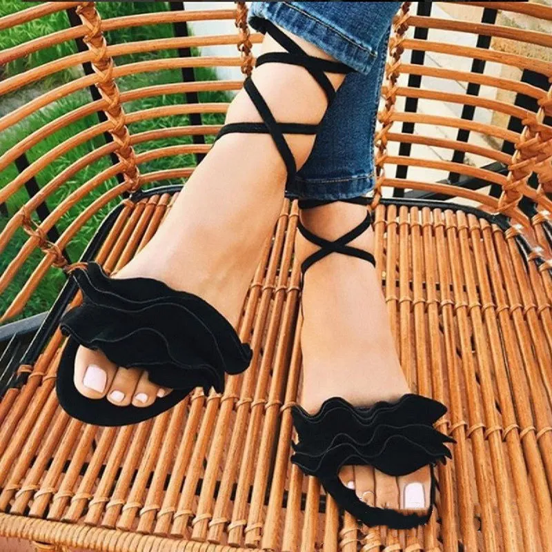 Women's plus size suede flower flat sandals with ankle strap in black, side view