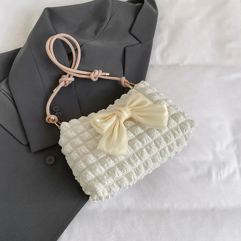 Street style canvas one-shoulder handbag in horizontal square shape with visible stitching.
