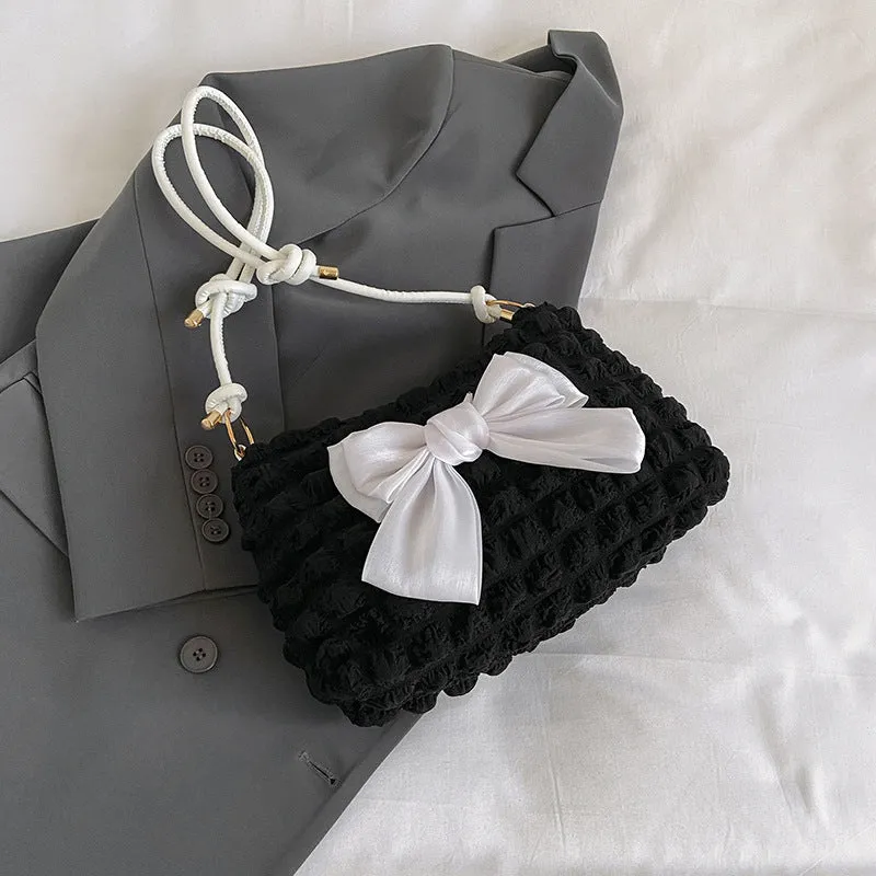 Street style canvas one-shoulder handbag in horizontal square shape with visible stitching.