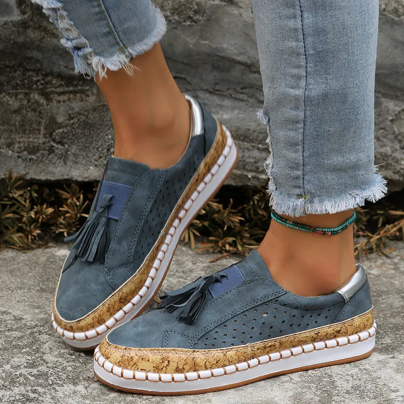 Women's tassel flats loafers in black with round toe, low heel, and cross strap detail