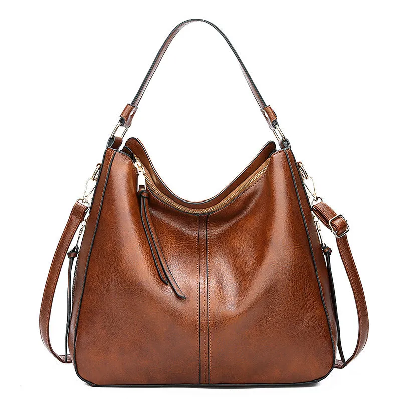 Hobos zipper bucket bag in black with adjustable shoulder strap on a woman's shoulder