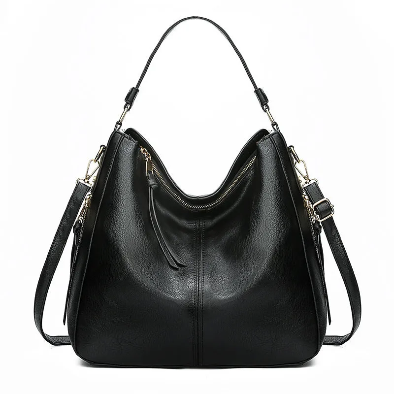 Hobos zipper bucket bag in black with adjustable shoulder strap on a woman's shoulder