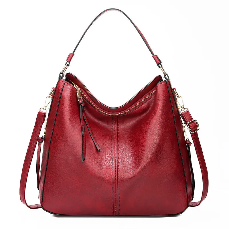 Hobos zipper bucket bag in black with adjustable shoulder strap on a woman's shoulder