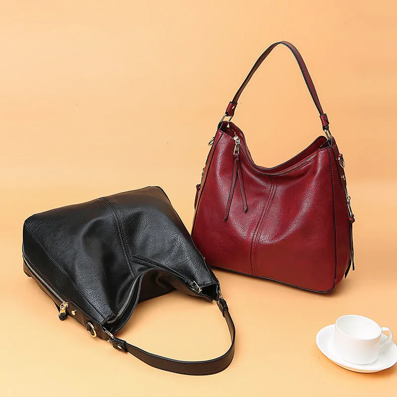Hobos zipper bucket bag in black with adjustable shoulder strap on a woman's shoulder