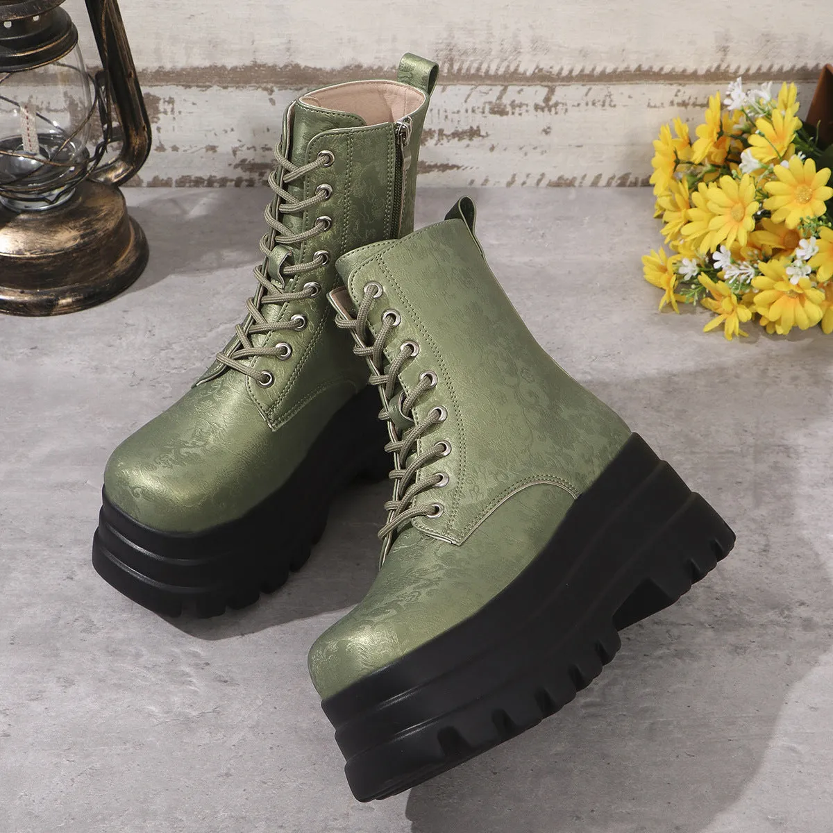Women's black platform Martin boots with patchwork detail and side zip on a white background.