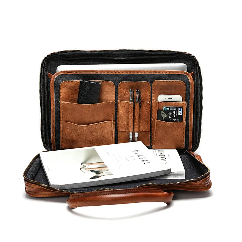 Men's vintage brown leather briefcase open to show internal laptop and camera pockets.