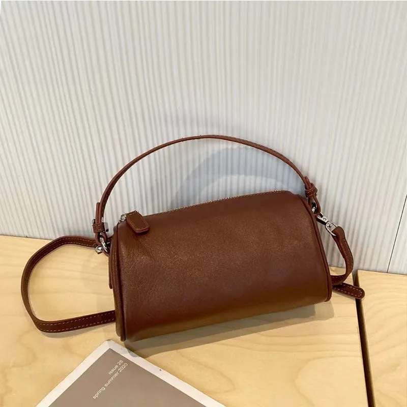 Cylindrical crossbody phone bag in soft genuine leather, shown in one of six colours including black or brown.