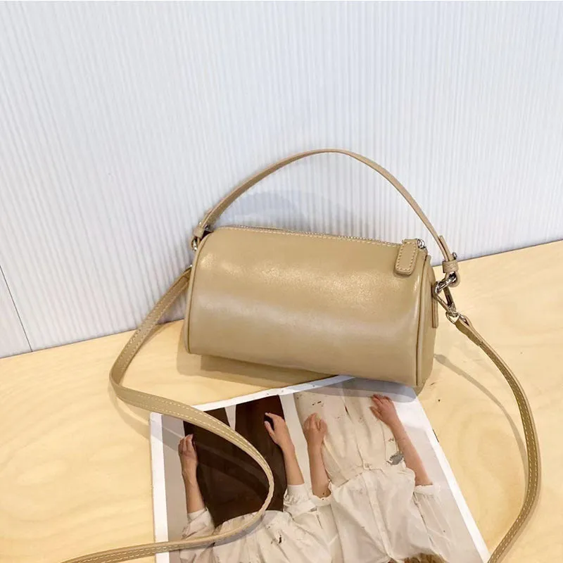 Cylindrical crossbody phone bag in soft genuine leather, shown in one of six colours including black or brown.