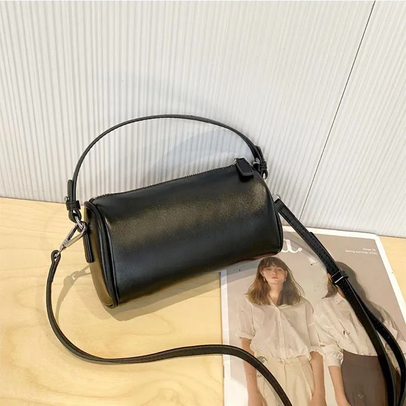 Cylindrical crossbody phone bag in soft genuine leather, shown in one of six colours including black or brown.
