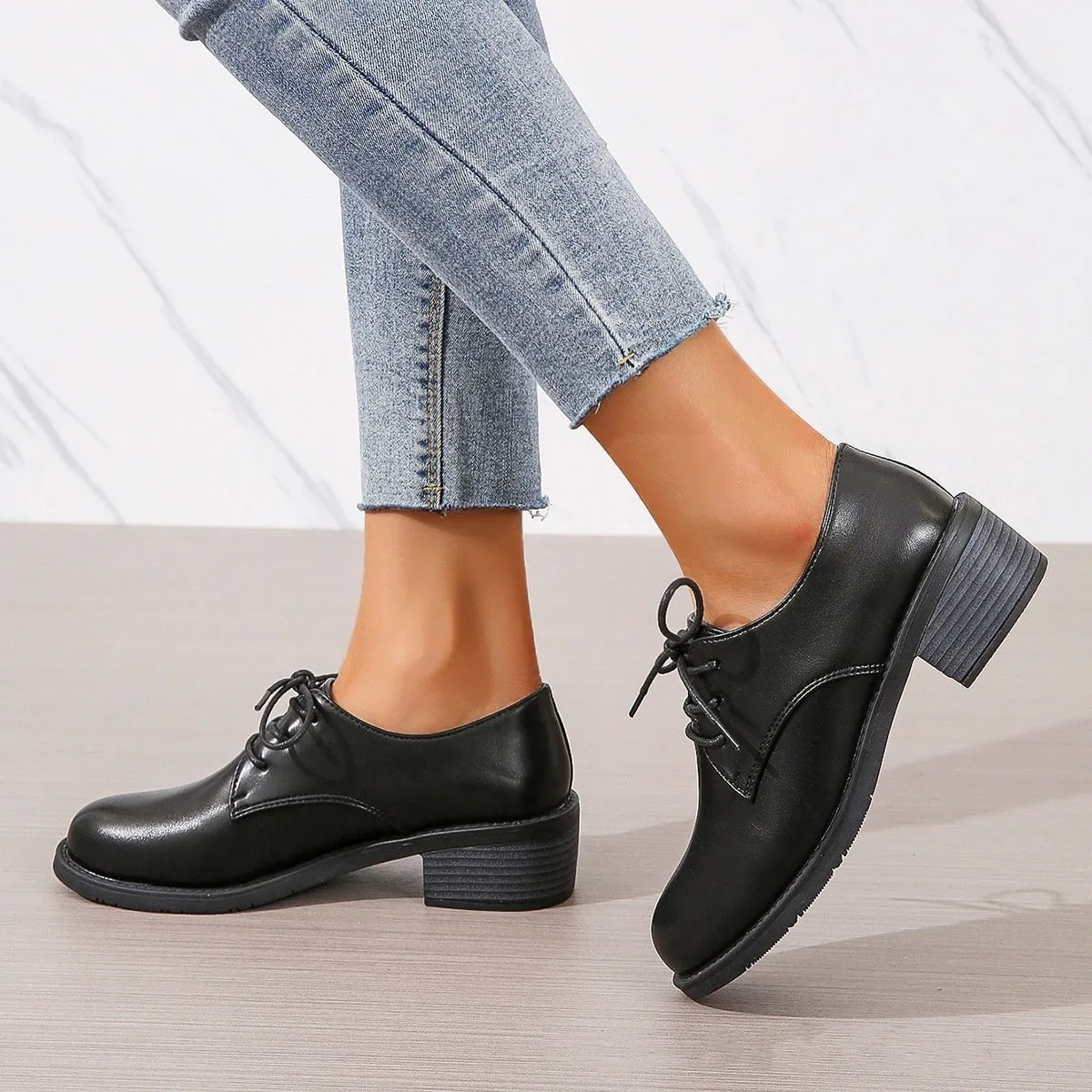 Black women's low-top work shoes with a chunky rubber heel and PU leather upper