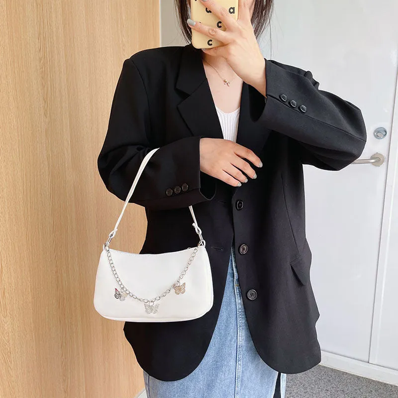 Women's black PU leather butterfly chain underarm bag showing crossbody wear with retro styling
