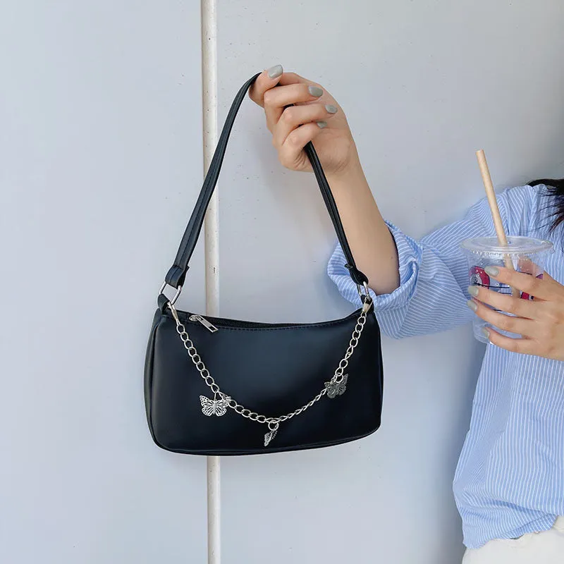 Women's black PU leather butterfly chain underarm bag showing crossbody wear with retro styling