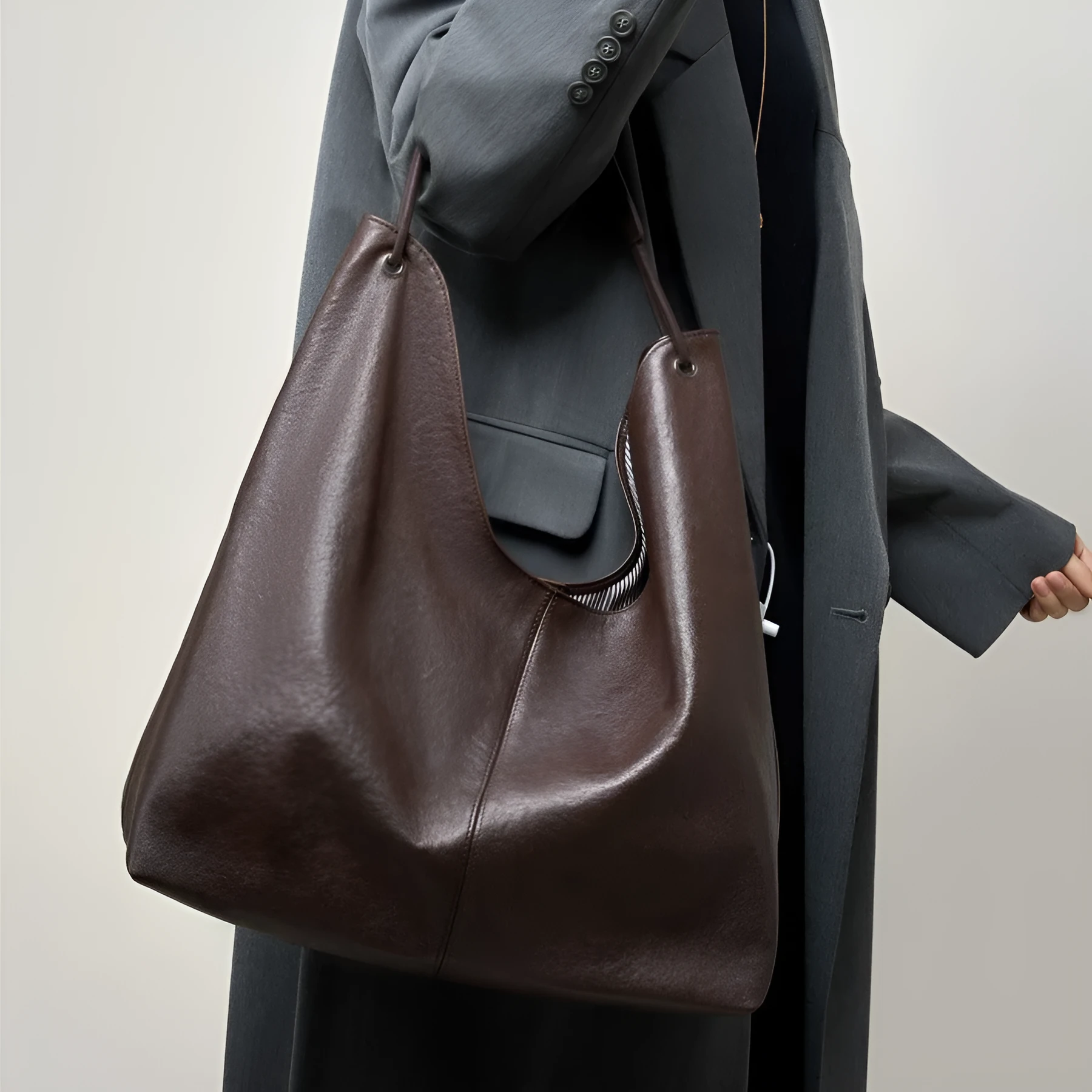 Brown genuine leather tote bag with contrast stitching and large capacity, front view on white background