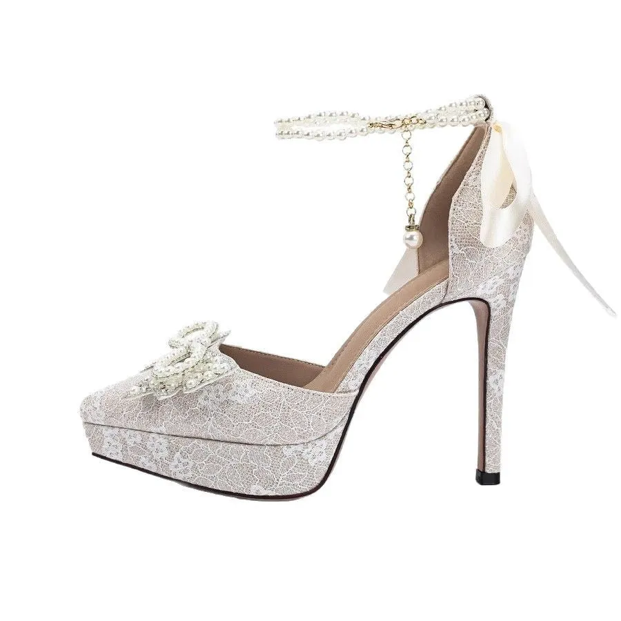 Beige PU high heels sandals with pearl bow and silver hollowed detailing on a light background