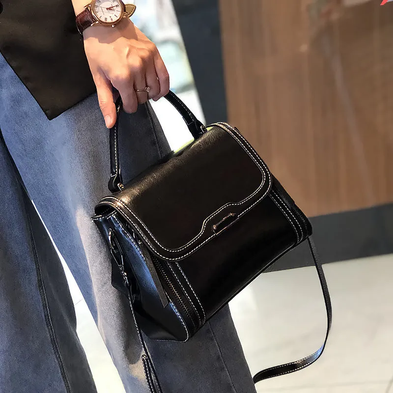 Women's brown genuine oil wax leather messenger bag with double shoulder straps and visible sewing lines