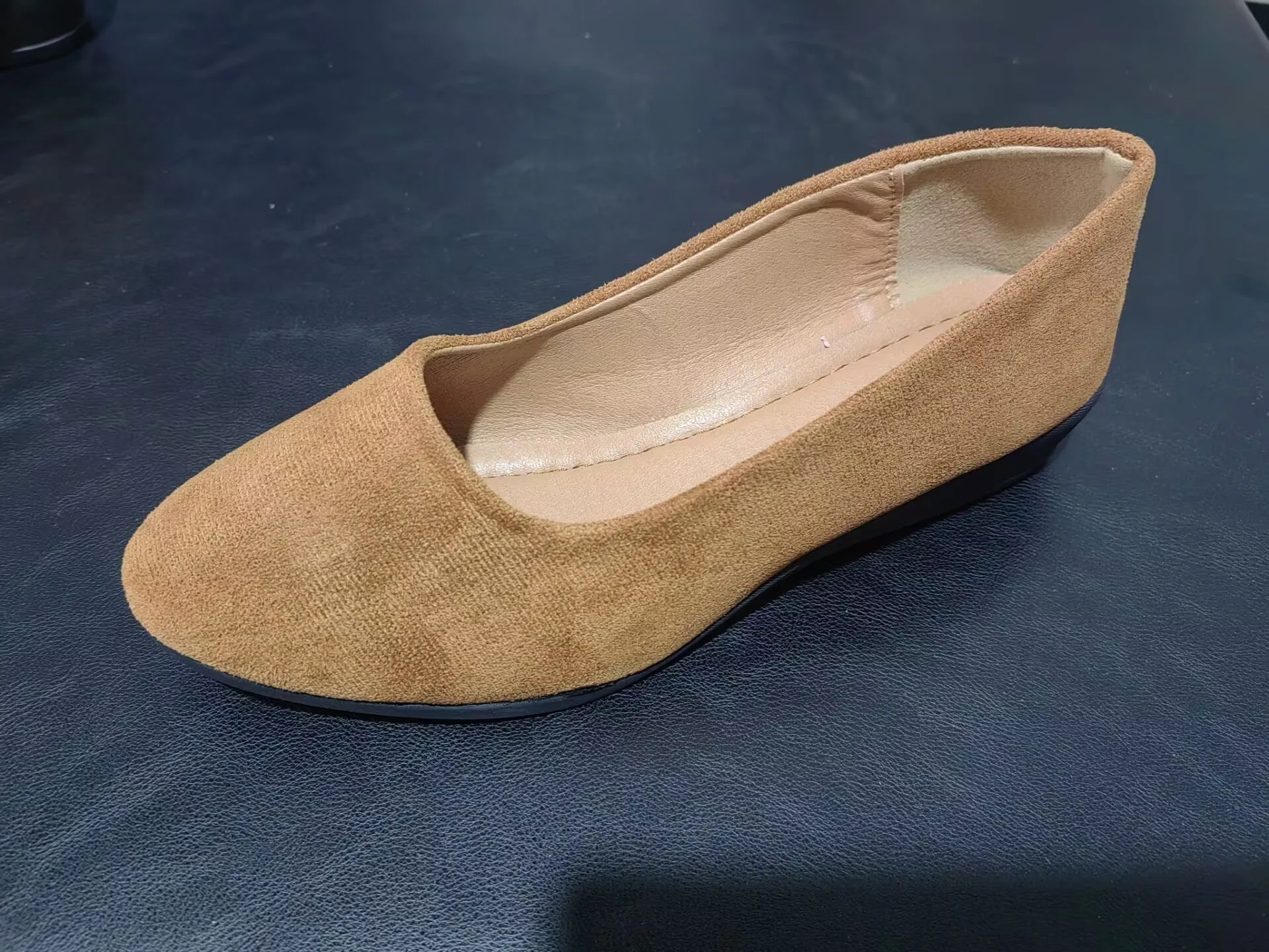 Women's light brown suede wedge pumps with a round toe and shallow mouth design on a rubber sole.
