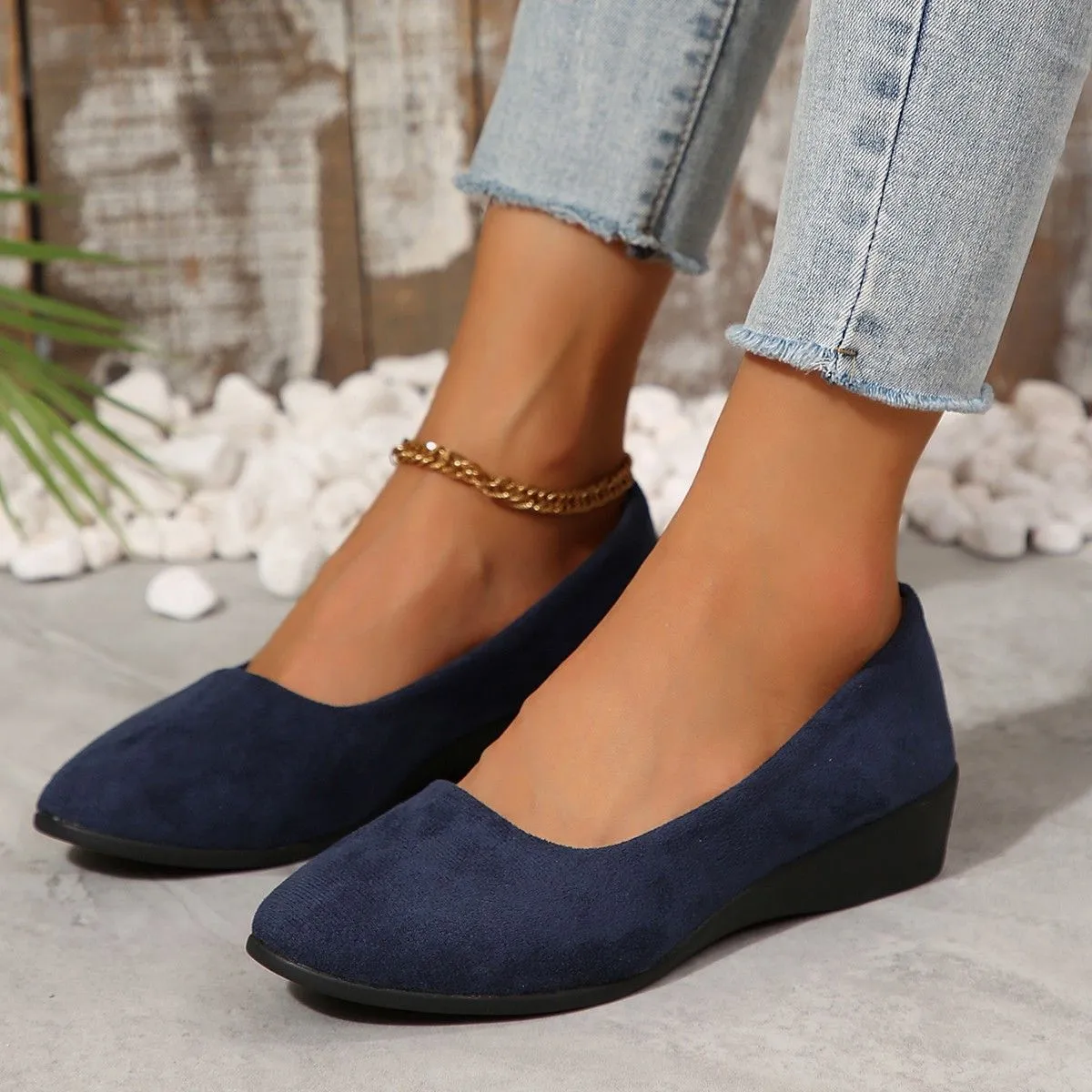 Women's light brown suede wedge pumps with a round toe and shallow mouth design on a rubber sole.