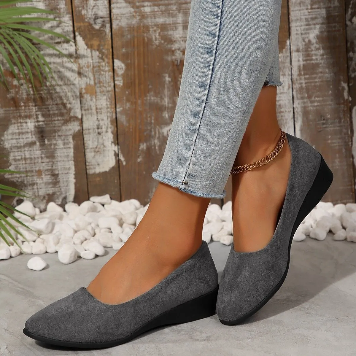 Women's light brown suede wedge pumps with a round toe and shallow mouth design on a rubber sole.
