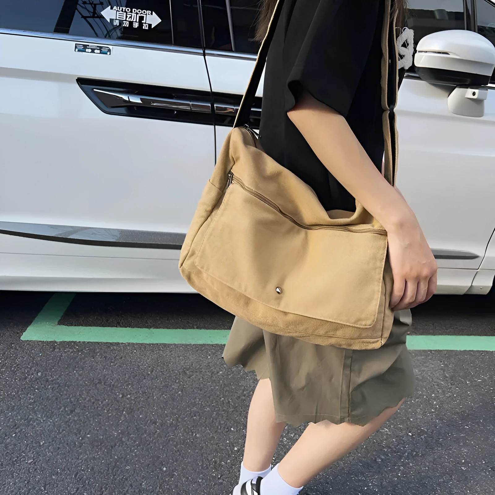 Washed canvas crossbody bag for women in black with single shoulder strap and clamshell shape