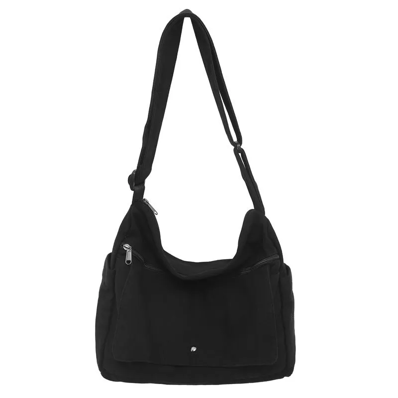Washed canvas crossbody bag for women in black with single shoulder strap and clamshell shape
