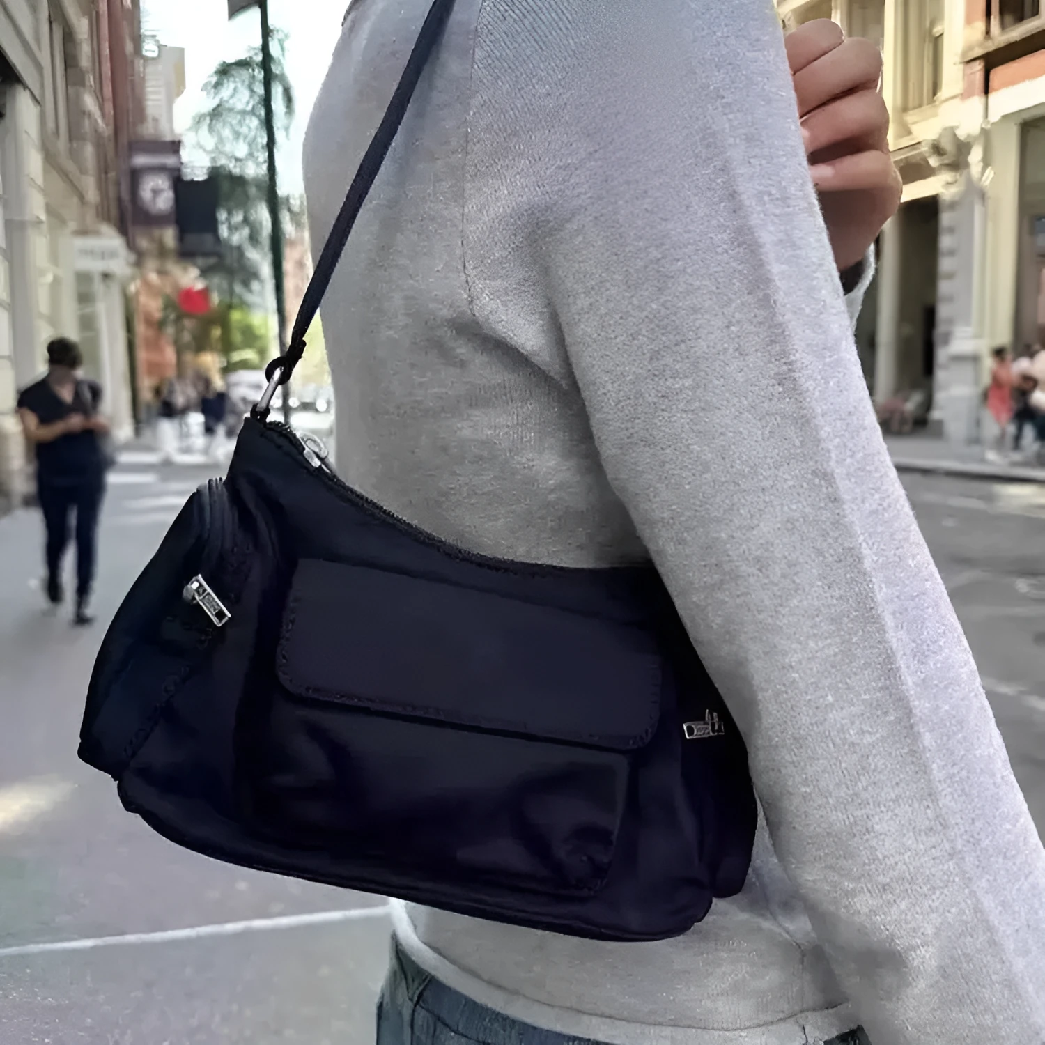 Black nylon lightweight shoulder bag with double pockets showing side line design detail