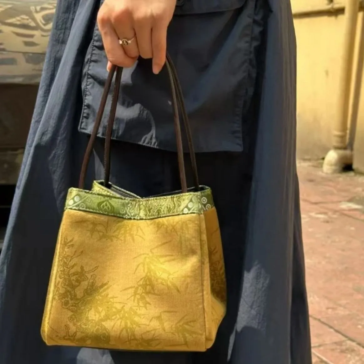 Gold PU leather small square handbag with tassels and sewing line detail on white background