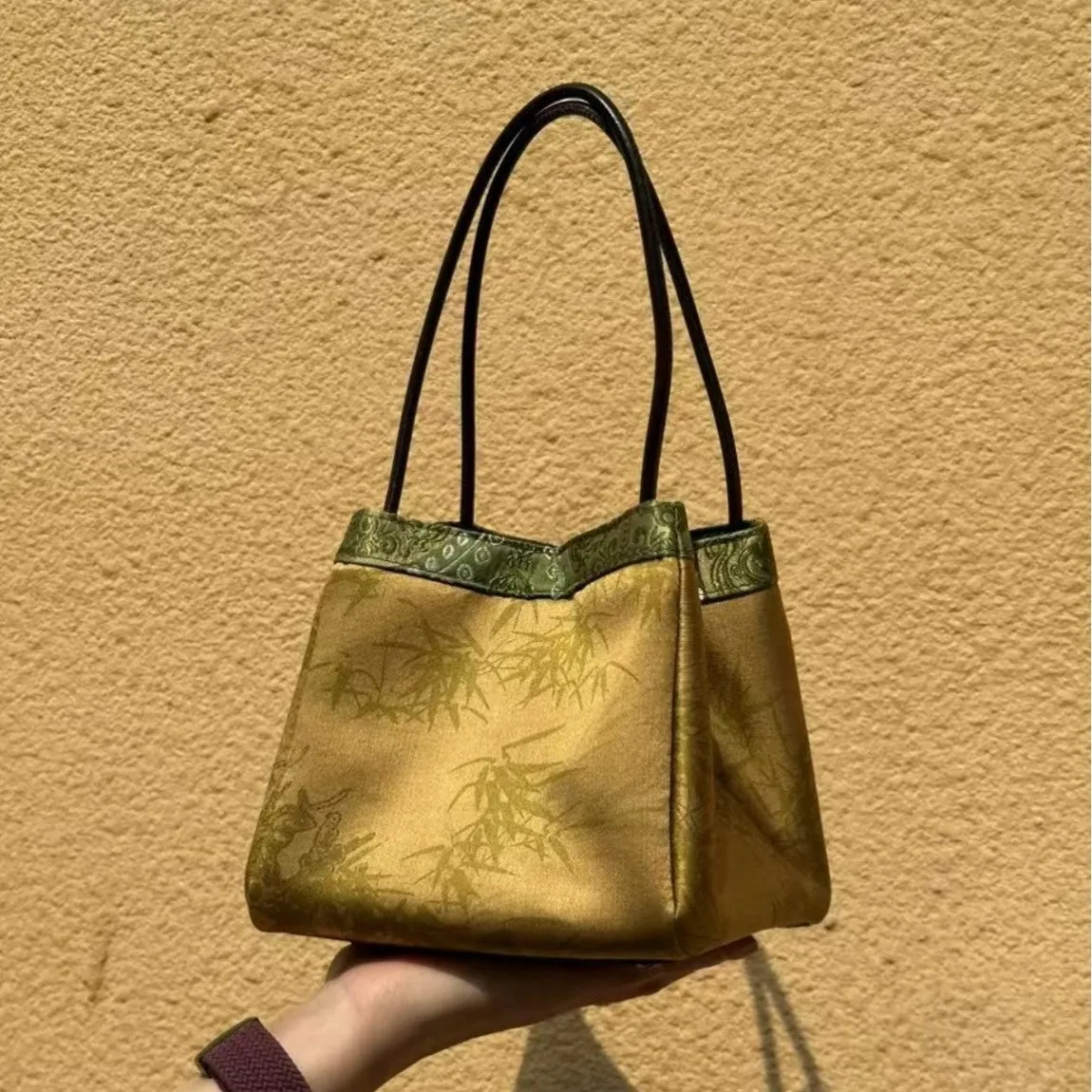 Gold PU leather small square handbag with tassels and sewing line detail on white background