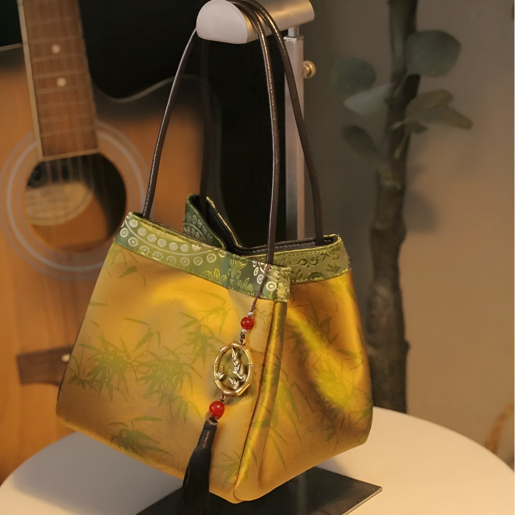 Gold PU leather small square handbag with tassels and sewing line detail on white background