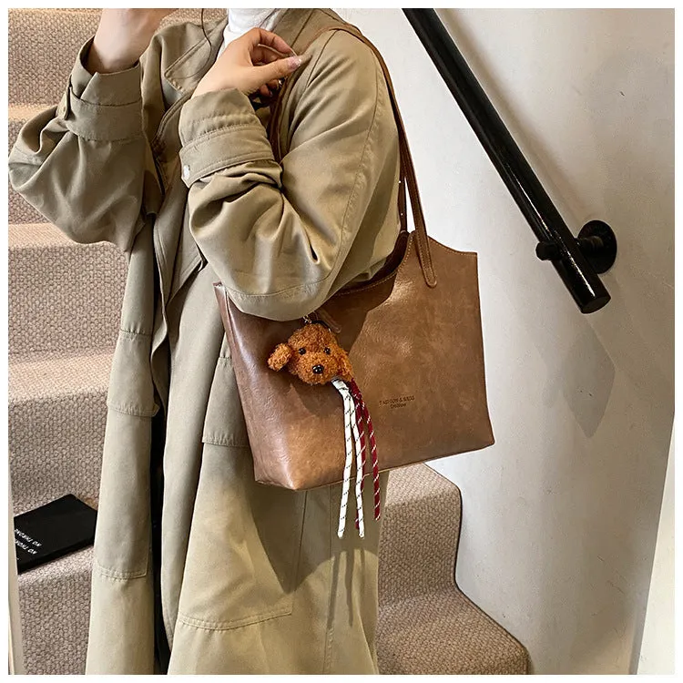 Women's PU commuter shoulder bag in black with stitching details and optional ribbon pendant, horizontal square shape