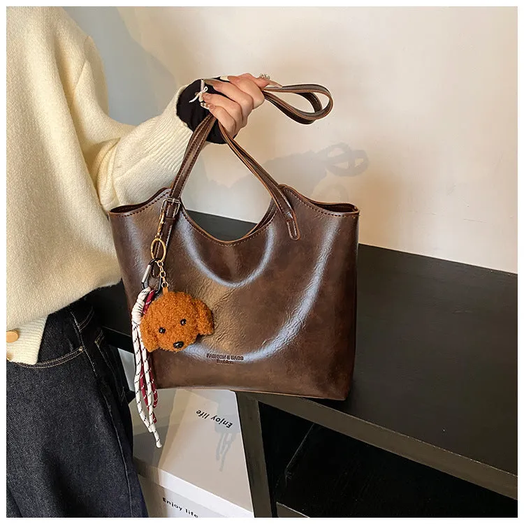 Women's PU commuter shoulder bag in black with stitching details and optional ribbon pendant, horizontal square shape