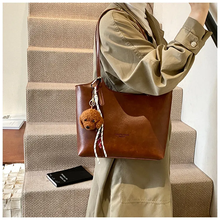 Women's PU commuter shoulder bag in black with stitching details and optional ribbon pendant, horizontal square shape