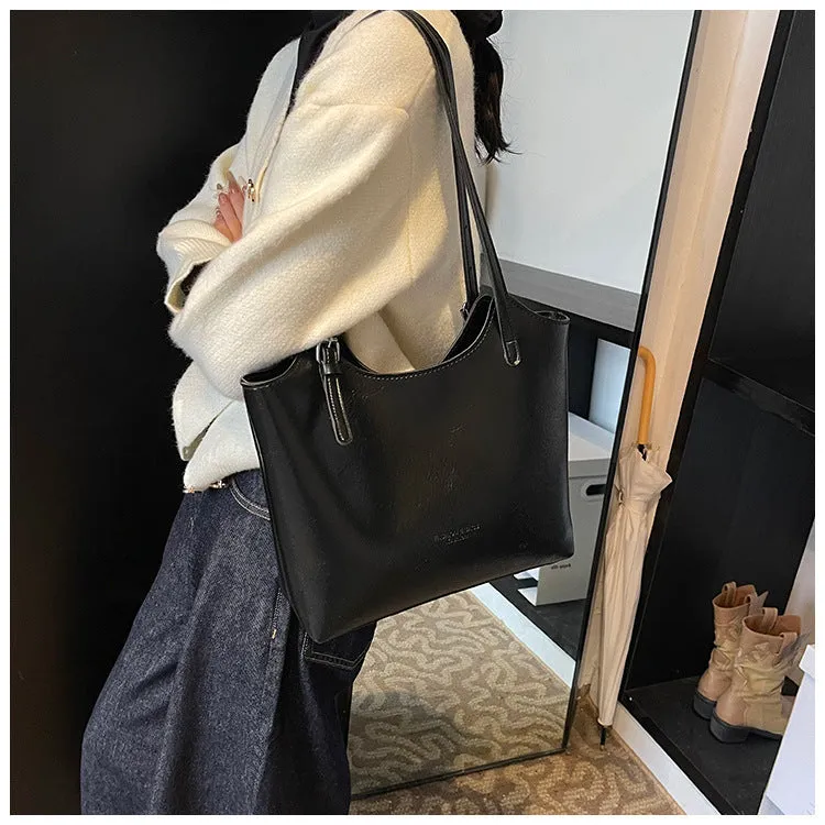 Women's PU commuter shoulder bag in black with stitching details and optional ribbon pendant, horizontal square shape