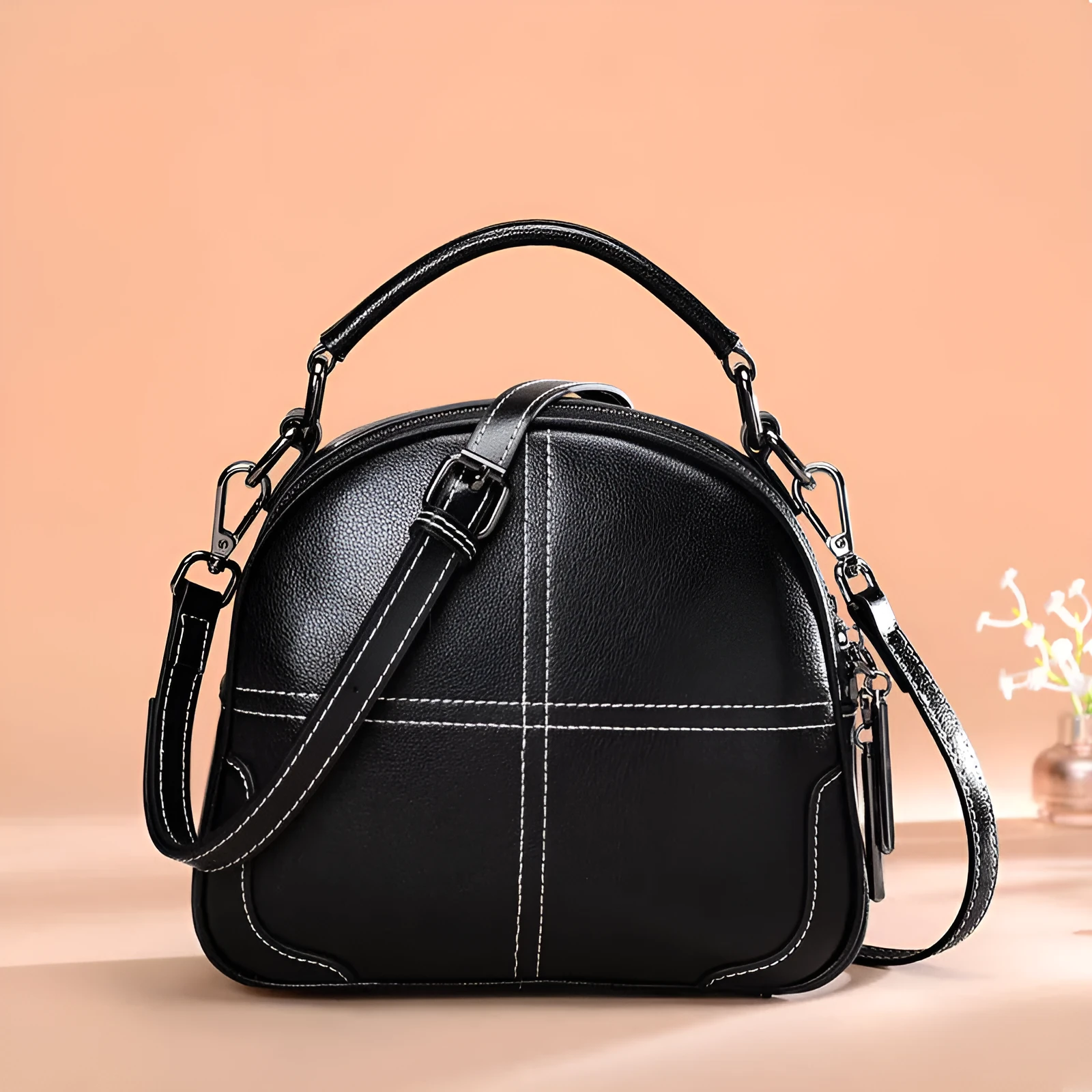 Round women's leather handbag with soft handles and a zip, shown in a choice of colours.