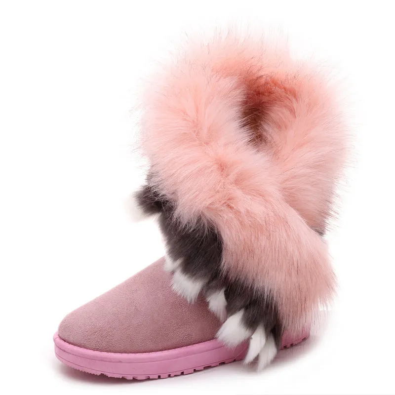 Women's winter snow boots in suede with fluffy fox fur trim and rubber sole on a snowy path