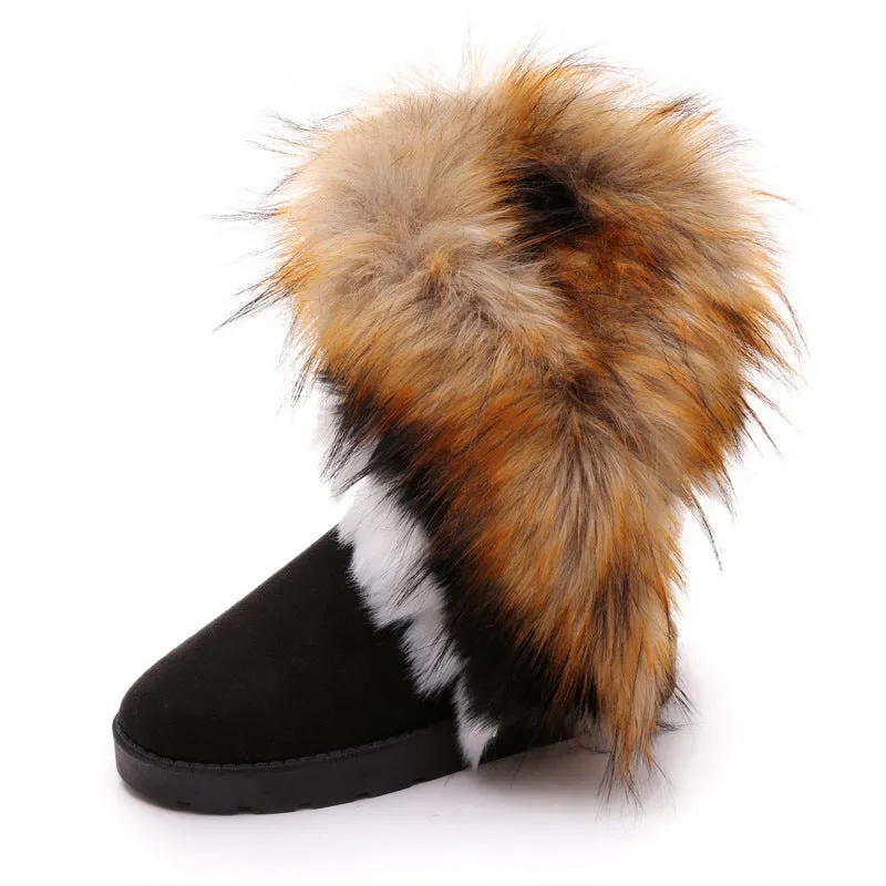 Women's winter snow boots in suede with fluffy fox fur trim and rubber sole on a snowy path