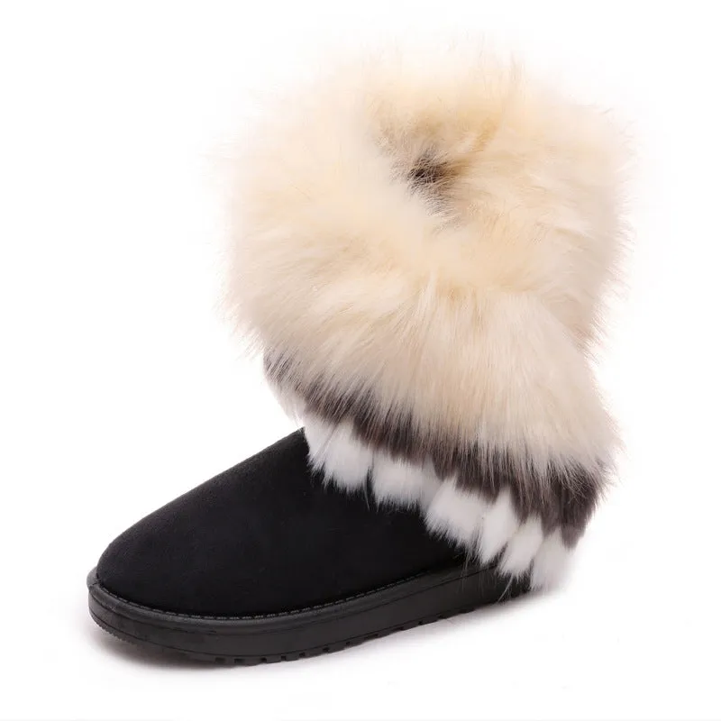 Women's winter snow boots in suede with fluffy fox fur trim and rubber sole on a snowy path