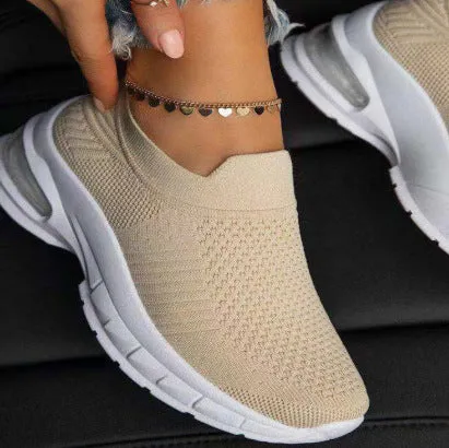 White women's mesh sneakers with rubber sole and flat heel shown from side angle