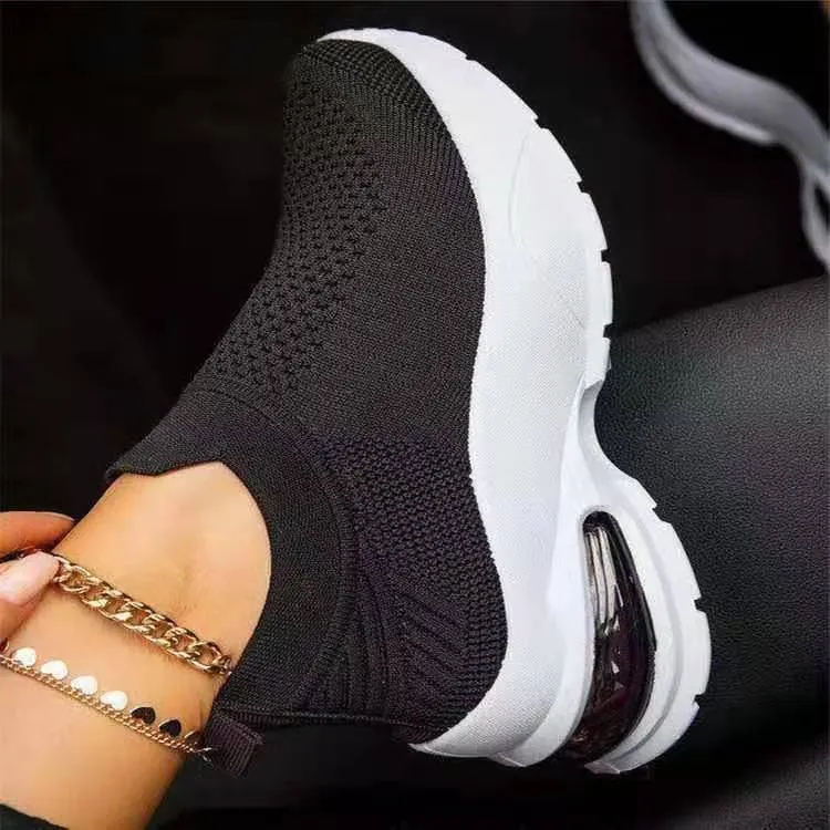 White women's mesh sneakers with rubber sole and flat heel shown from side angle