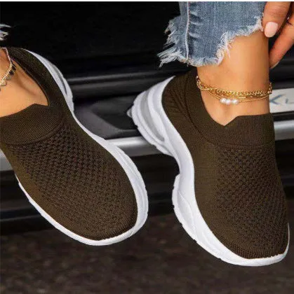 White women's mesh sneakers with rubber sole and flat heel shown from side angle